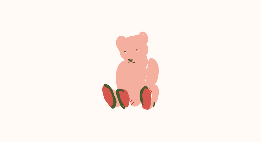 a pink teddy bear seating on the floor