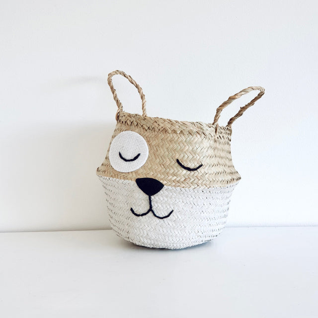 Woven basket with a dog face on a white background