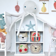 Children's room with white bookshelf, colorful baskets, and decorative items.