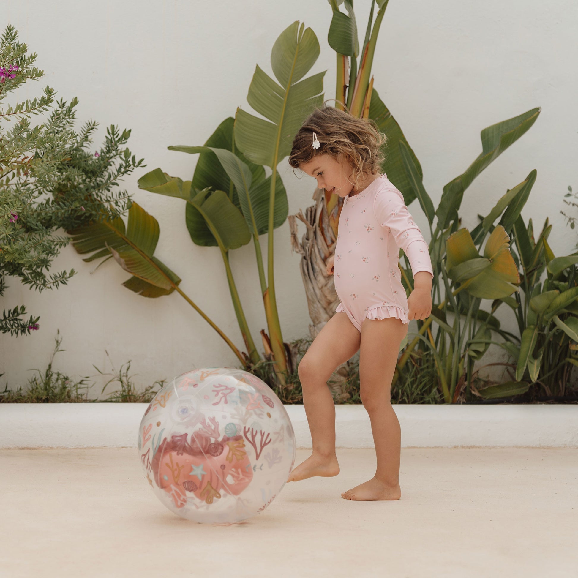 Child kicking Little Dutch 3D beach ball in pink