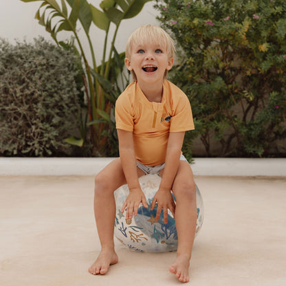 Laughing child sitting on Little Dutch 3D Beach Ball in blue