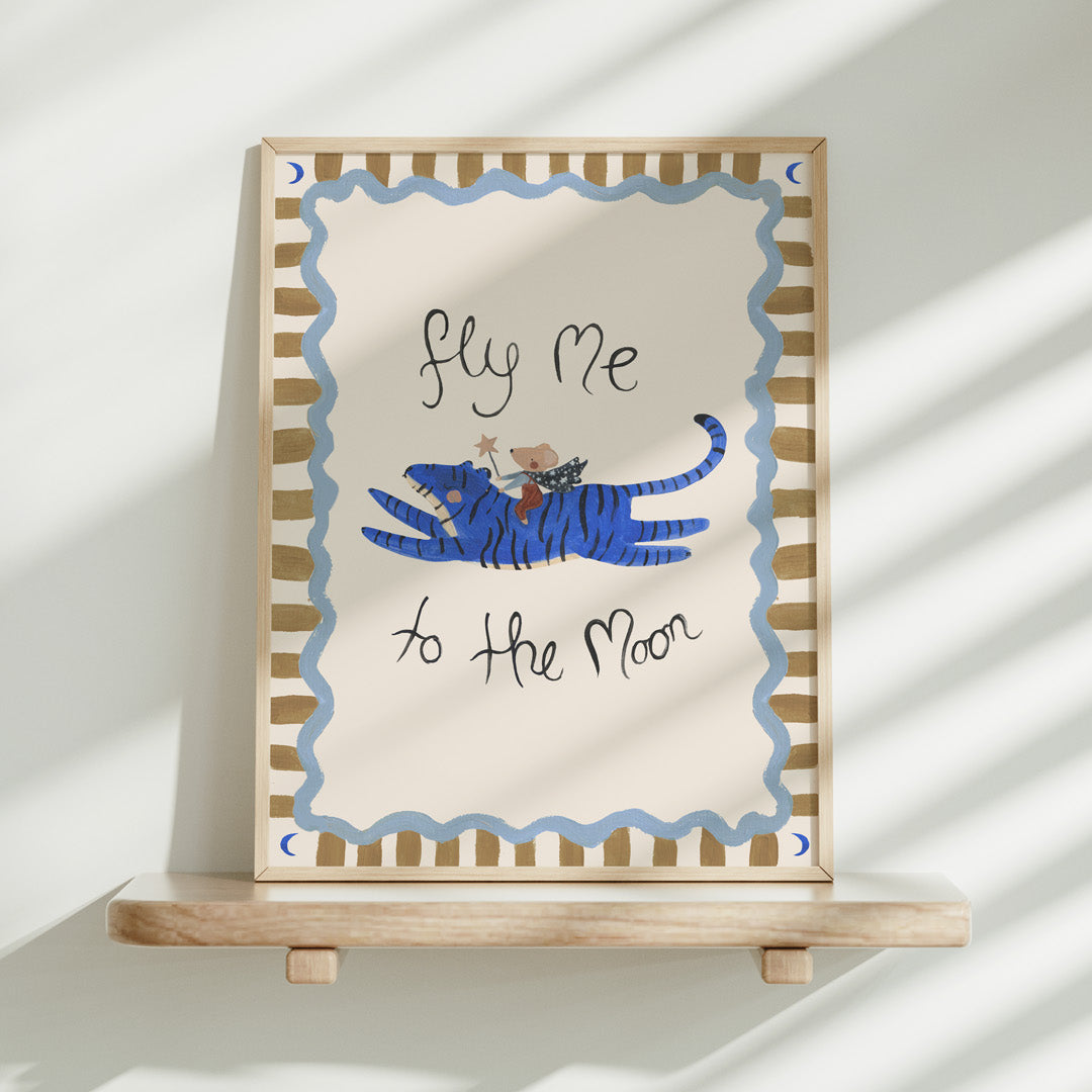 Framed artwork with a blue tiger and text 'fly me to the moon' on a white background