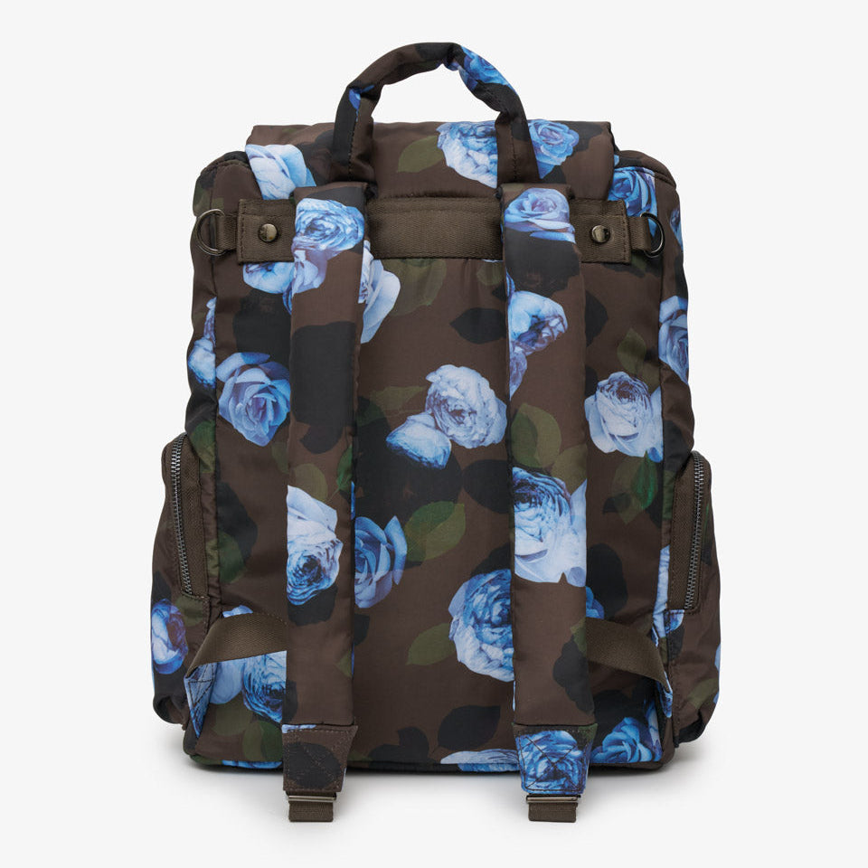 A brown backpack featuring a blue and white rose floral print, shown from the back against a light gray background.
