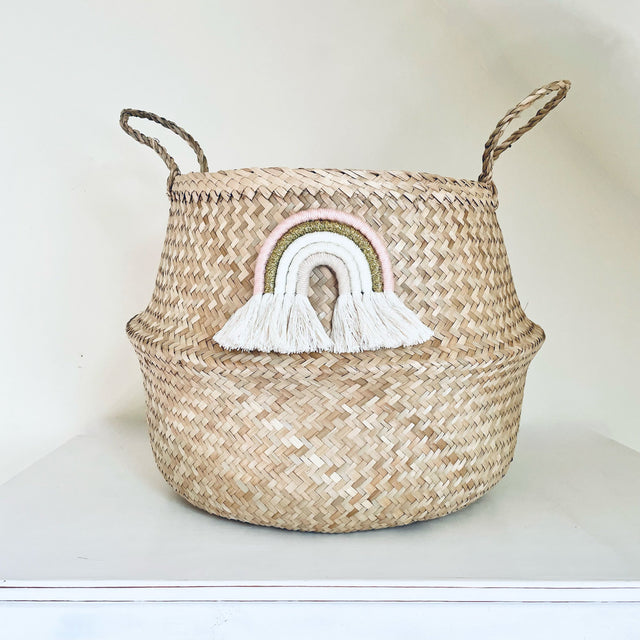 Woven basket with a rainbow tassel decoration on a white background