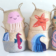 Three woven baskets with colorful sea-themed decorations on a white background