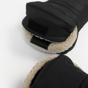Close-up of a black winter glove showing the fleece-lined cuff and hook-and-loop strap closure, with a second glove partially visible below on a white background.