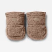 A pair of Finnson Stroller Mittens in a warm taupe-brown sherpa fleece, featuring a small tan brand patch on the front cuff. The booties are photographed from a top-down angle on a clean, light gray background.