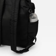 Finnson Black changing backpack with a pocket containing a baby bottle on a white background