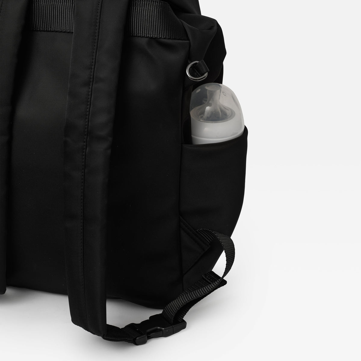 Finnson Black changing backpack with a pocket containing a baby bottle on a white background