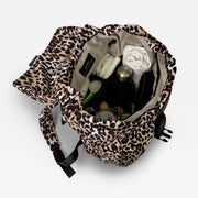 Finnson Leopard print changing backpack with baby items on a light gray background