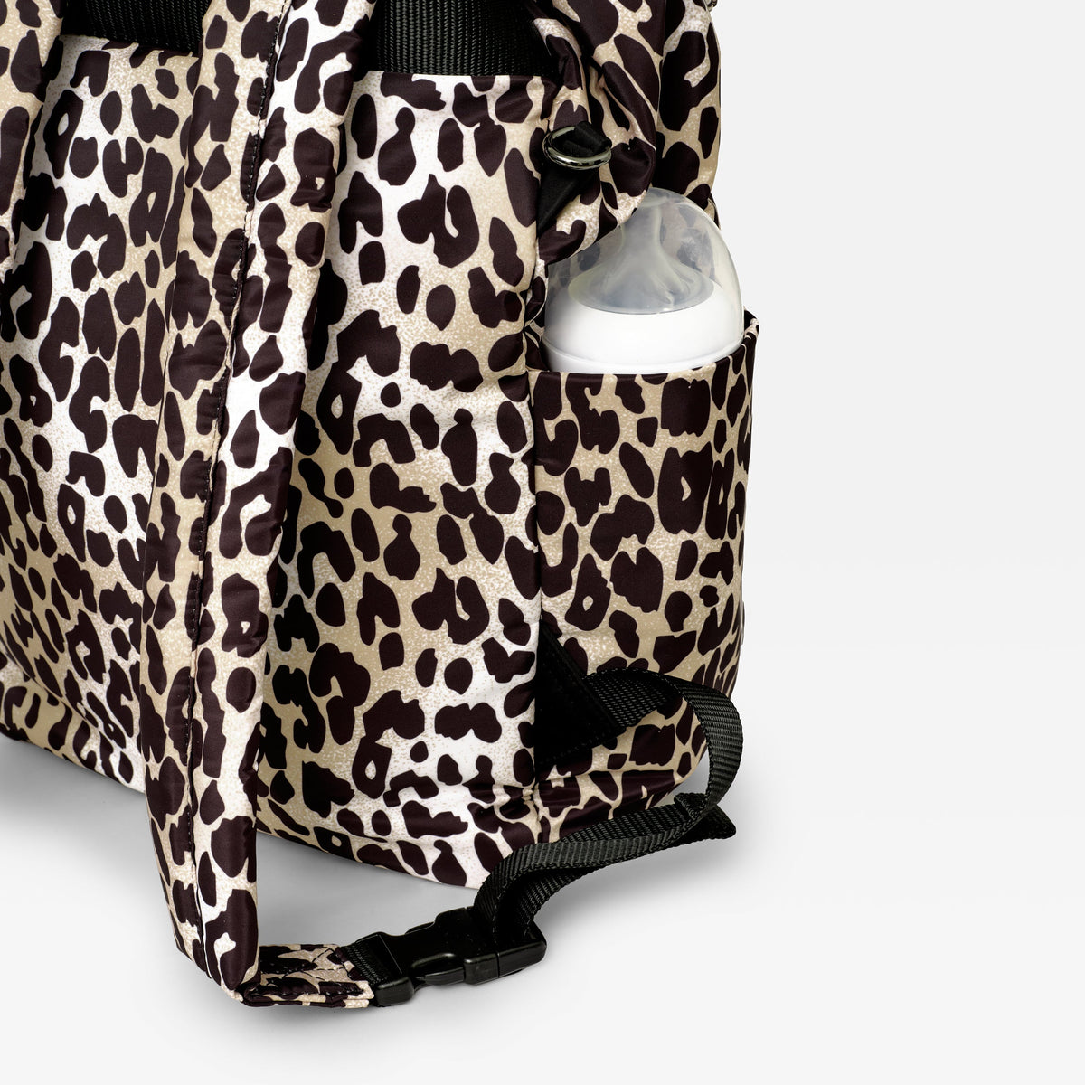 Finnson Leopard print changing bag with a baby bottle inside on a light gray background