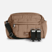 Finnson tan canvas crossbody stroller organiser bag with a black adjustable strap and two black webbing straps with silver metal buckles, displayed on a light gray background.
