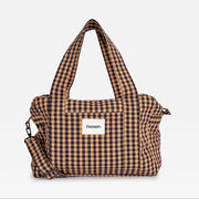 A brown and beige gingham checkered duffel bag with dual top handles and a detachable shoulder strap, featuring a white front patch with the brand name 'Finnsort'.