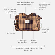 A brown and black checkered shoulder bag with text callouts and dotted lines explaining features such as grab handles, detachable strap, side D-rings, BCI cotton, lightweight durability, and dimensions on a light gray background.