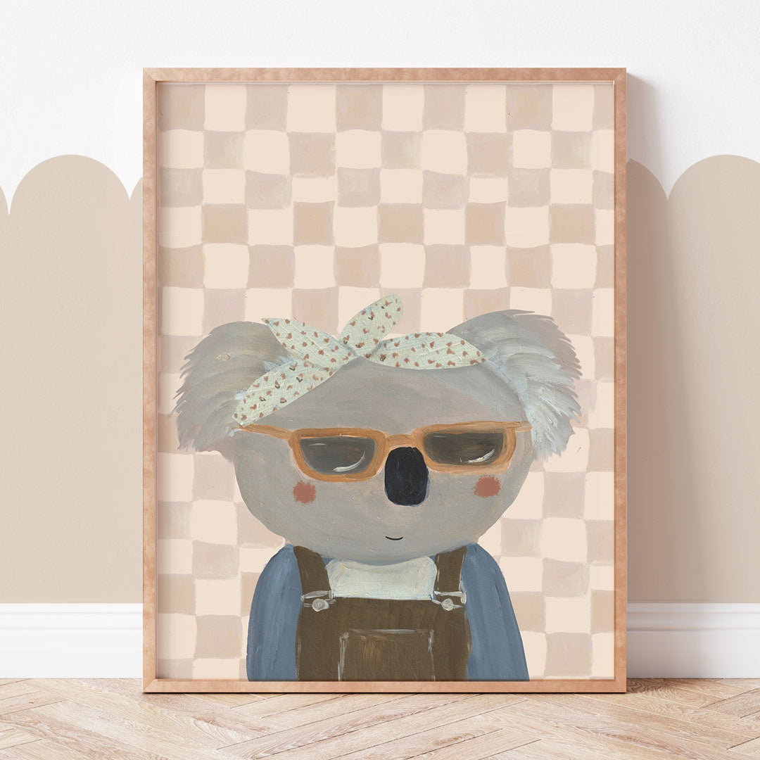 Framed artwork of a koala wearing glasses and a bandana on a checkered background.