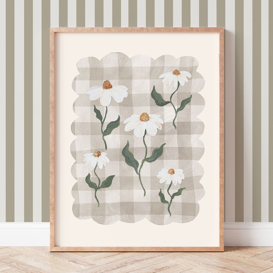 Framed artwork with a daisy design on a wall with striped wallpaper
