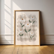 Framed floral artwork on a wall with sunlight casting shadows