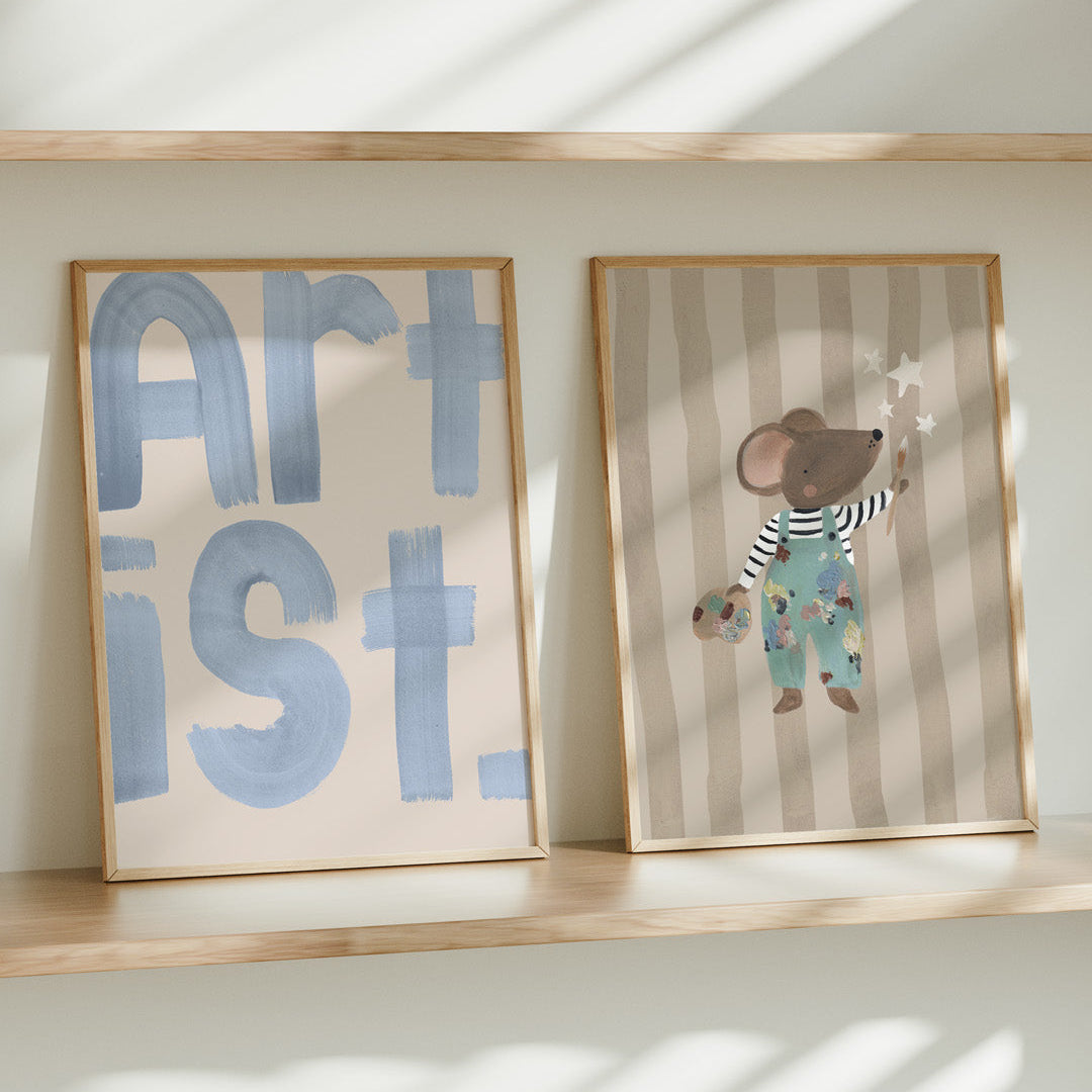Two framed artworks on a shelf with 'ARTIST' and a cartoon mouse design.