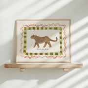Framed artwork with a jaguar illustration and the phrase 'Be brave, be kind, be you' on a white wall