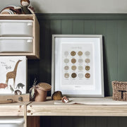 Children's play area with wooden shelf, toys, and framed artwork against a green wall.