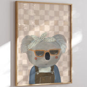 Framed artwork of a koala wearing sunglasses and a headband on a checkered background