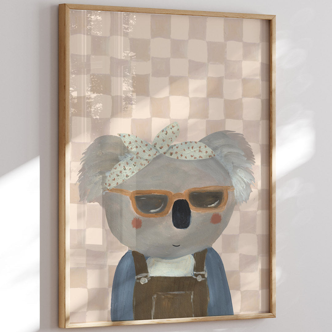 Framed artwork of a koala wearing sunglasses and a headband on a checkered background