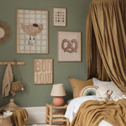 Cosy bedroom with green walls, framed artwork, and a bed with brown bedding.
