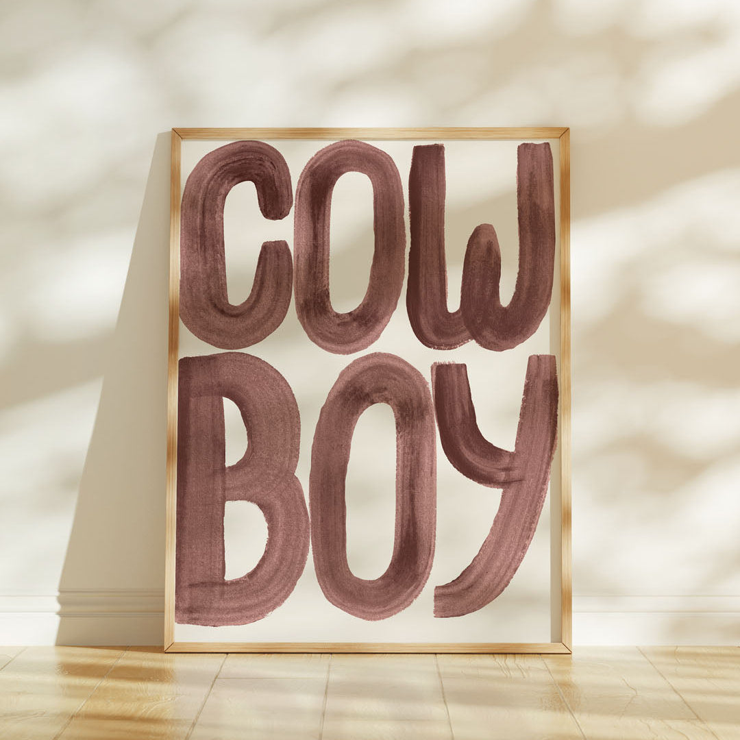 Framed artwork with 'COW BOY' text on a light background