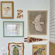Wall with various framed pictures and decorations including a peace sign and cartoon characters.