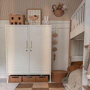 Children's room with a white cabinet, toys, and a bed.