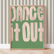 Framed artwork with 'Dance It Out' text on a green background, placed against a striped wall.