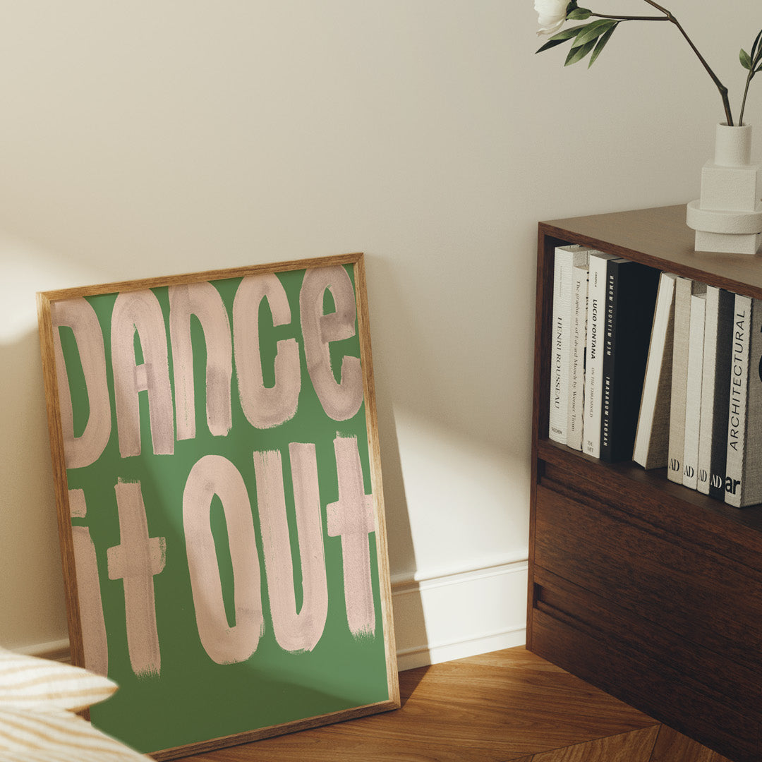 Room interior with a framed poster reading 'Dance It Out' on a wall.