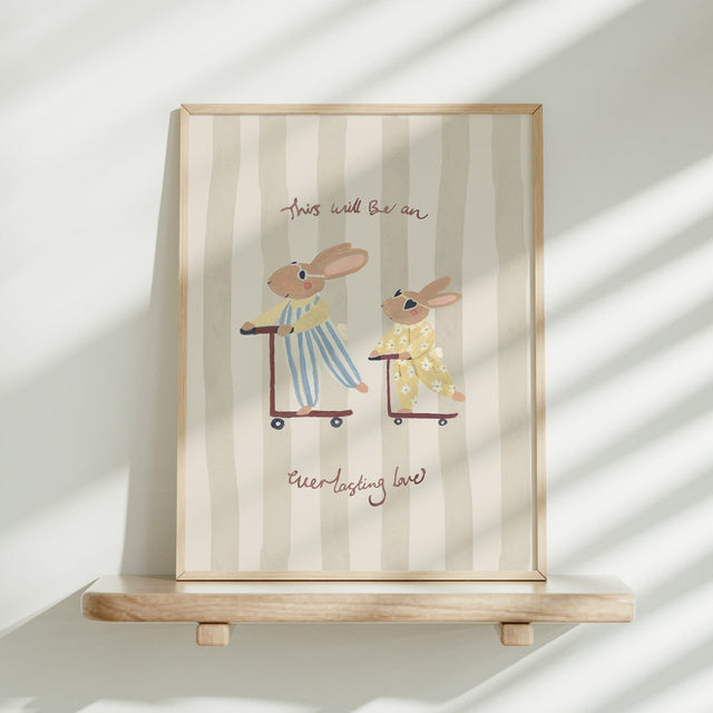 Framed artwork with bunnies on scooters on a striped background and the words 'This will be an everlasting love'