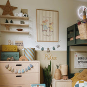 Children's room with wooden dresser, shelves, and decorative items.