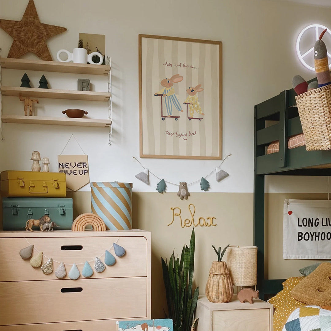 Children's room with wooden dresser, shelves, and decorative items.