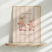 Framed artwork with cartoon bunnies on scooters and text on a striped background