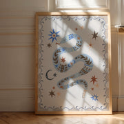 Decorative wall art with a snake design in a wooden frame on a light-colored wall.