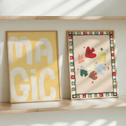 Two framed artworks on a shelf with 'MAGIC' on a yellow background and colorful abstract design.
