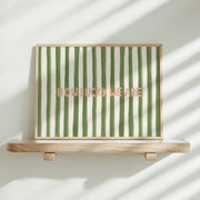 Framed artwork with green and white stripes and 'HOW LUCKY WE ARE' text on a wooden stand.