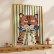 Framed artwork of a tiger with a bow tie on a wall above a wooden shelf.