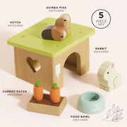 Le Toy Van Bunny & Guinea Pig set with a wooden hutch, two guinea pigs, a bunny rabbit, a food bowl, and a carrot patch, all included as part of a five-piece set designed for imaginative play. 