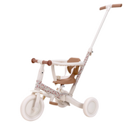 Off white 4 in 1 trike for children with floral detail, featuring a secure seat, handle and pedal arrangement suitable for different stages of child development.