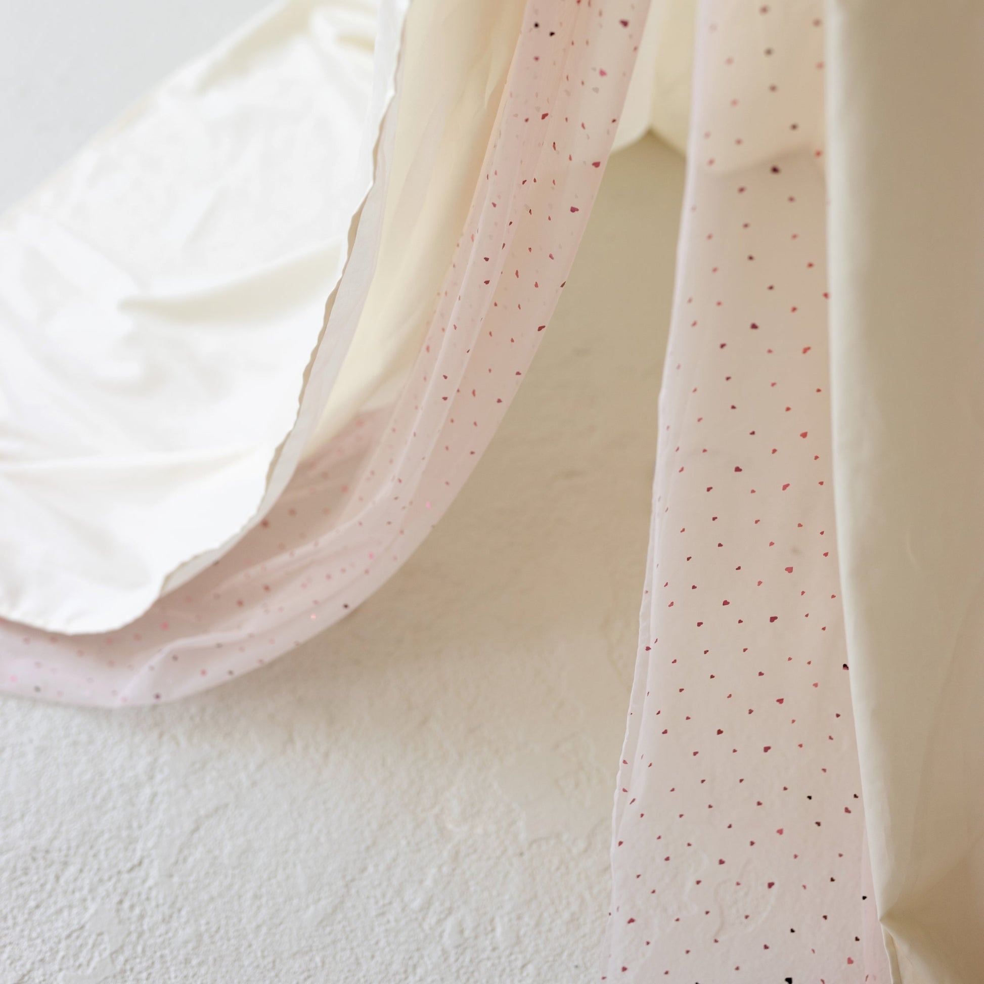 Close-up of canopy with small red hearts on a white background