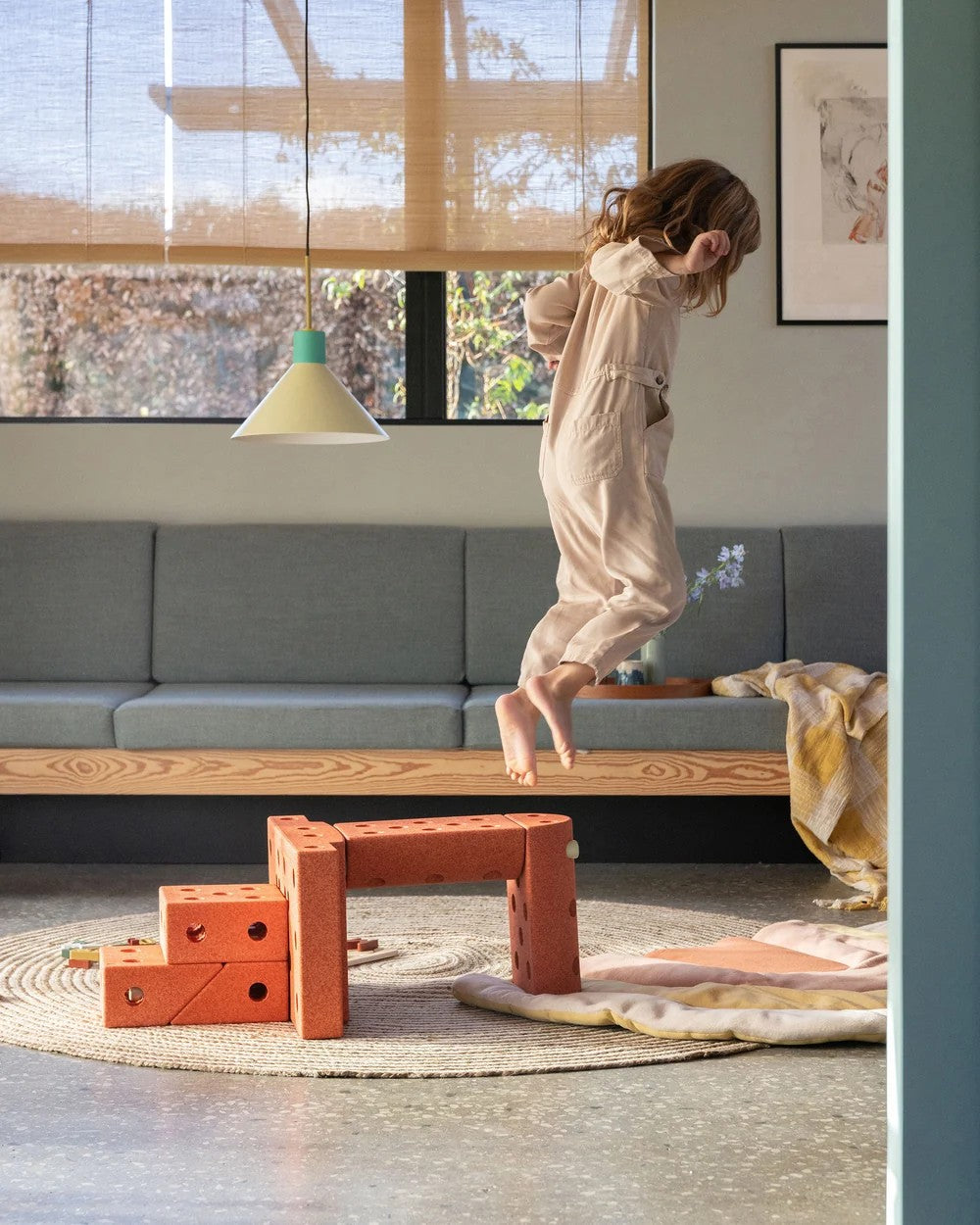 Child playing with wooden blocks in a modern living room.