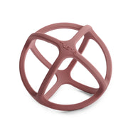 A Mushie dusty rose silicone teether in a spherical shape, open-frame design and the brand name 'mushie' embossed on the center, shown on a clean white background.
