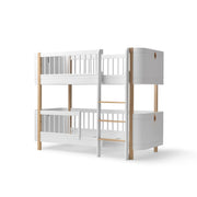Oliver Furniture Wood Mini+ Low Bunk Bed in white and oak, designed for comfortable and stylish shared spaces, with a ladder on the right and the ability to convert into two junior beds. 