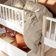 White wooden bed guard with safety railings mounted on Oliver Furniture Wood Original bed, featuring solid birchwood construction and protective mesh design for toddler sleep safety.