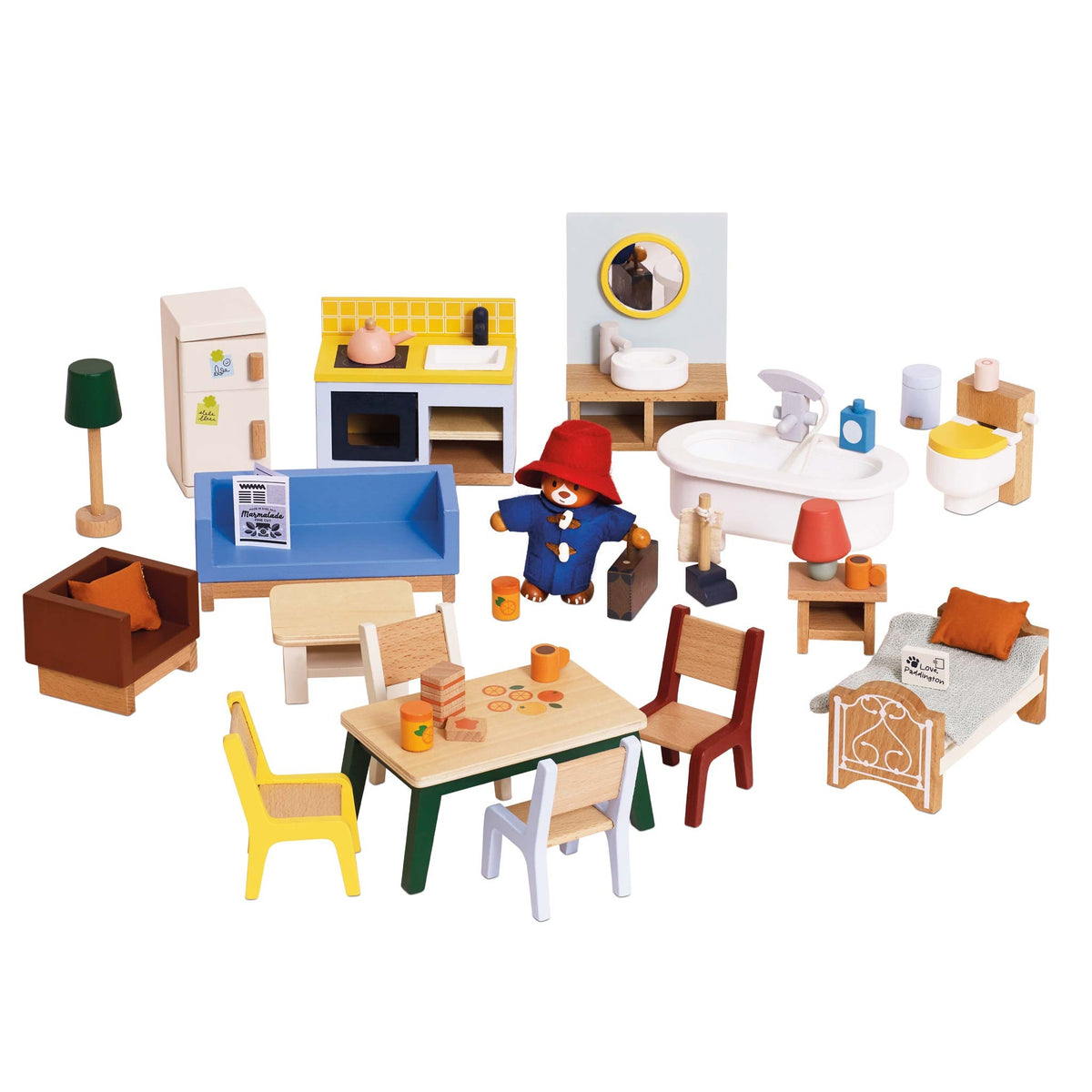 A wooden dollhouse playset featuring a living room, kitchen, bathroom, and bedroom with small furniture pieces and a Paddington Bear figure, photographed on a white background.