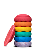 A stack of colourful stapelstein stepping stones in red, orange, yellow, green, blue, and purple, with one red wobble board.