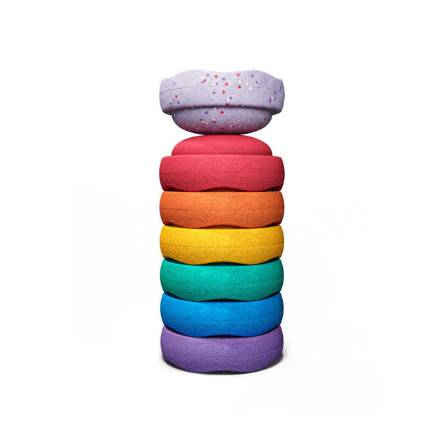 A stack of seven soft, stapelstein winter special mini stepping stones in a rainbow colour sequence, with an additional light purple speckled stone. 